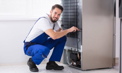 Photo Of Male Technician Fixing Refrigerator In Kitchen